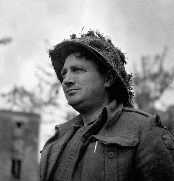Pte. Gus McKinnon of the Highland Light Infantry of Canada advancing toward Caen, France, 9 July 1944.