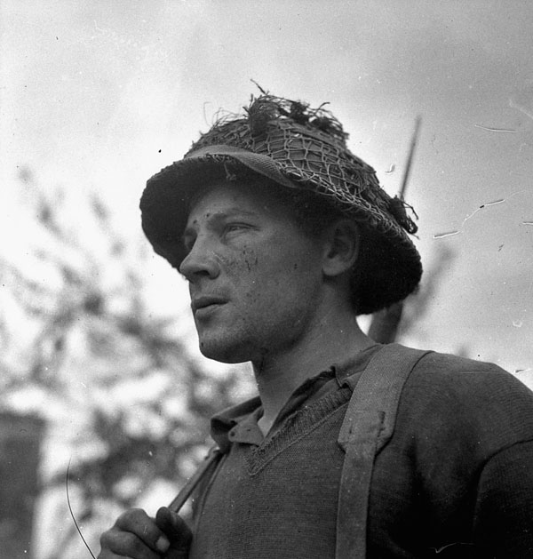 Private Harry Parker of the Highland Light Infantry of Canada advancing toward Caen, France, 9 July 1944.