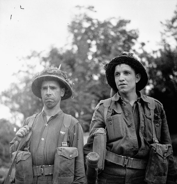 Private Eddie Feltham (left) and Private John Cote of the Highland Light Infantry of Canada advancing toward Caen, France, 9 July 1944.