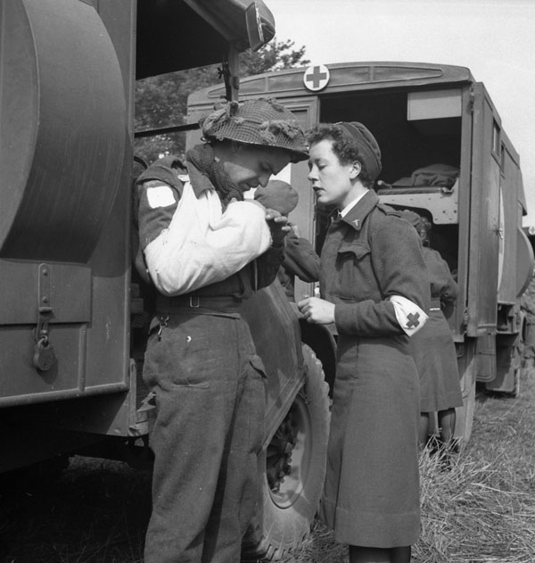 Pte. F. Madore with Nursing Sister M.F. Giles waiting for an air-evacuation from an R.C.A.F. Spitfire base, Normandy, France, 16 June 1944.