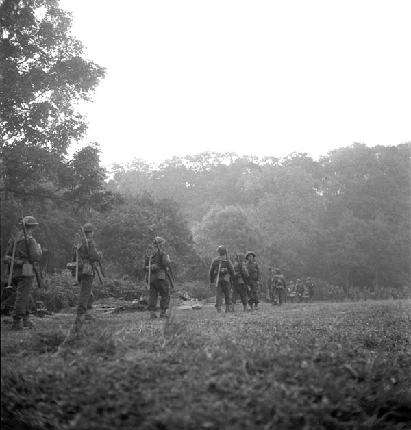 Infantrymen of Le Régiment de la Chaudière preparing to launch a dawn attack across the Orne River, France, 18 July 1944.