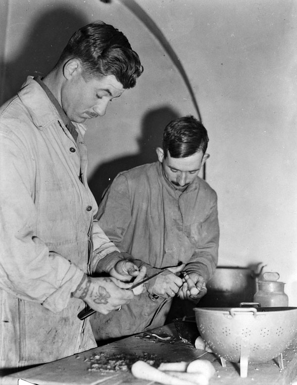 Student cooks Privates H.A. Foyland and L.C. Rand of the Royal Canadian Army Service Corps (R.C.A.S.C.) scraping carrots, San Vito di Ortona, Italy, January 1944.