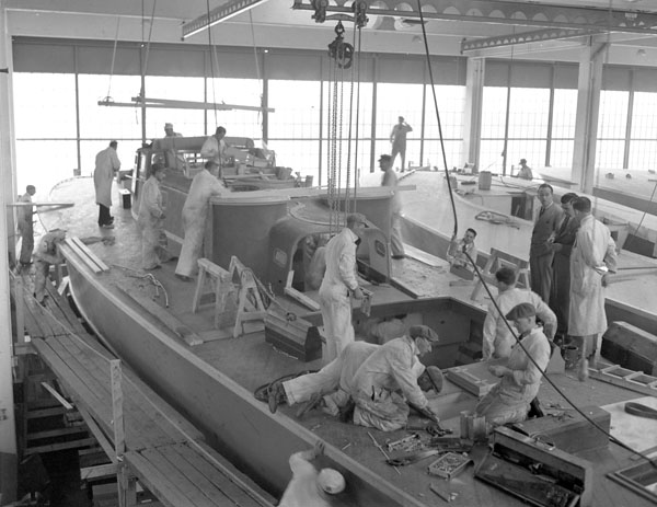 Workers on the deck of a motor torpedo boat, under construction at Canadian Power Boat Company, Montreal, Québec, Canada, 24 April 1941.