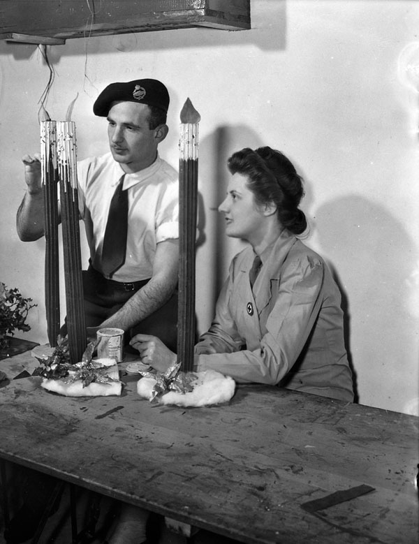 Trooper Julius Lustofsky and Handicrofts Officer May Beasley of the Canadian Red Cross making Christmas decorations at No.18 Canadian General Hospital, Royal Canadian Army Medical Corps (R.C.A.M.C.), Colchester, England, 15 December 1944.