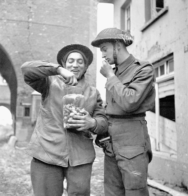 Privates G. Antosh and D.G. Ripley, both of The Queen's Own Cameron Highlanders of Canada, eating pickles from the jar, Xanten, Germany, 9 March 1945.