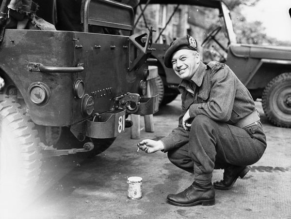 An unidentified officer of The Lorne Scots (Peel, Dufferin and Halton Regiment) stencilling the regiment's identification number on a jeep, England, ca. 30 May-1 June 1943.