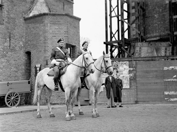 Private H.E. Easterbrook and Lance-Corporal T. Mudd, both of No.5 Provost Company, Canadian Provost Corps (C.P.C.), riding special grey horses at a Thanksgiving church service and parade, Groningen, Netherlands, 19 August 1945.