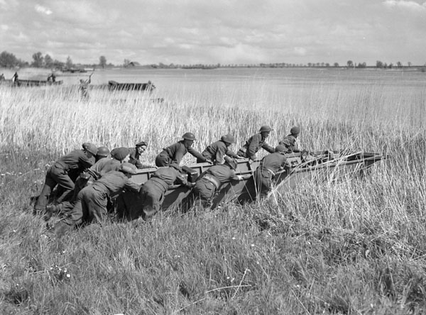 Personnel of the Royal Canadian Engineers (R.C.E.), 3rd Canadian Infantry Division, pushing a storm boat into the Ems River south of Emden, Germany, 28 April 1945.