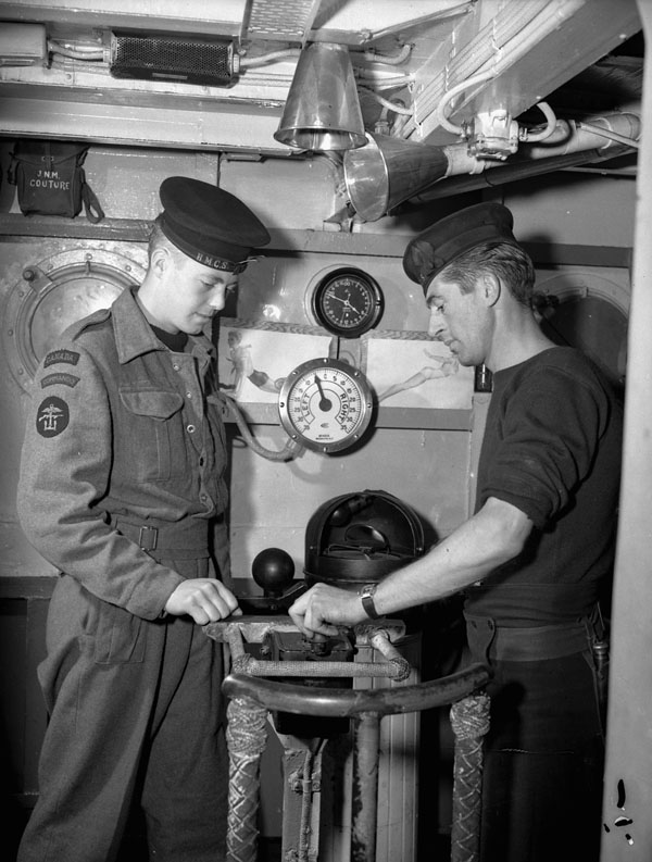 Leading Seaman J.B. Cloke (left) of the Royal Canadian Navy Beach Commandos talking with Leading Seaman J. Forsyth aboard a Landing Craft Infantry (Large) en route to France, 20 July 1944.