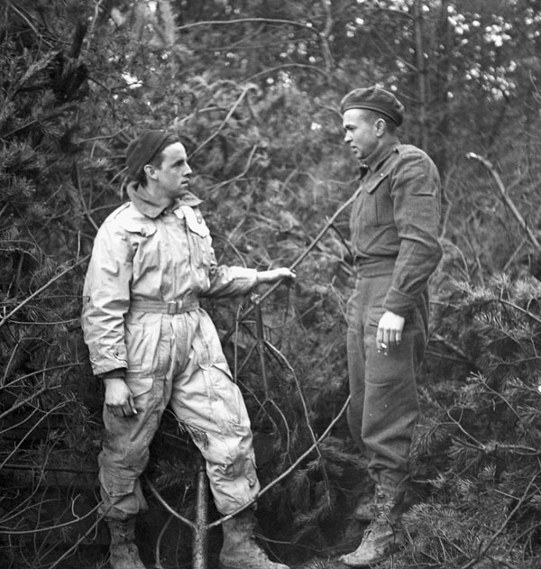 Privates Ken Russ (left) and Bill Freeland of the Royal Hamilton Light Infantry standing beside their camouflaged Wasp flamethrower carrier near Nijmegen, Netherlands, 8 February 1945.