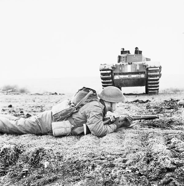 Private H.L. Wooton of the 1st Battalion, The Canadian Scottish Regiment,  covering the rear of a Churchill tank during a training exercise, England, 7 December 1942.