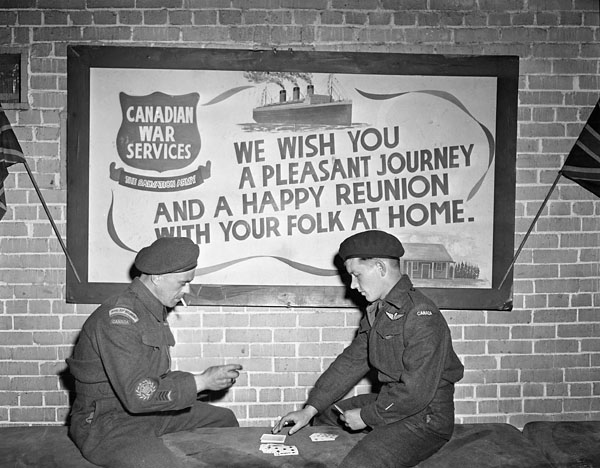Company Sergeant-Major G.O. Parent (left) of the Royal 22e Régiment playing gin rummy with an unidentified Canadian member of the disbanded First Special Service Force at No.1 Canadian Repatriation Depot (Canadian Army Miscellaneous Units), Thursley, England, 22 May 1945.