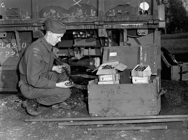 An unidentified member of the Royal Canadian Engineers (R.C.E.) examining  “Jackbits” detachable drills, England, ca. 1944.