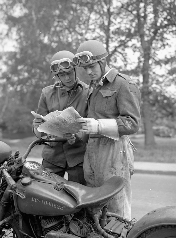 Despatch riders Doug Reid and Norman Given of the 9th Canadian Infantry Brigade checking the route of a convoy taking part in a training exercise, England, 17 May 1944.