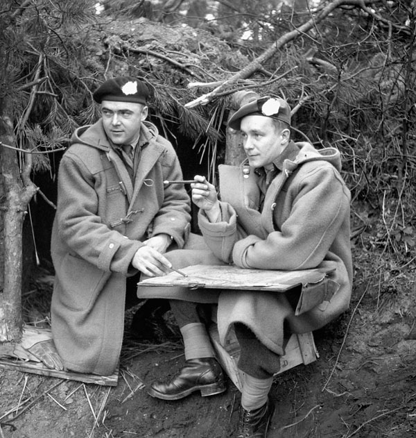 Captain D.N. McDonald, 12th Manitoba Dragoons, and Major R.B. MacNeill, The Queen's Own Cameron Highlanders of Canada, working outside a dugout in the Hochwald, Germany, ca. 10-11 March 1945.