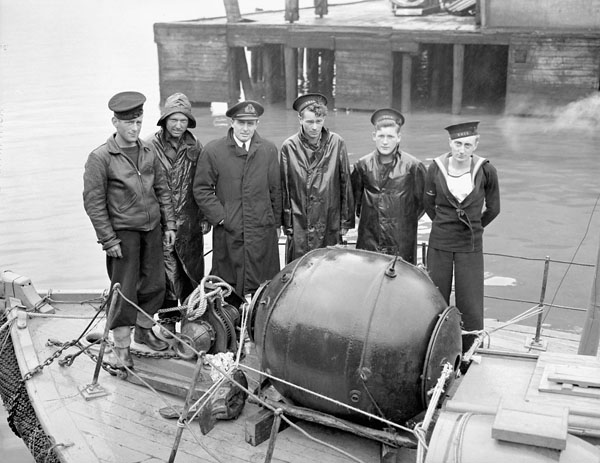 Naval personnel aboard S.S. MISS KELVIN (Harbour Craft 79) with a recovered mine, St. John's, Newfoundland, 13 July 1942.