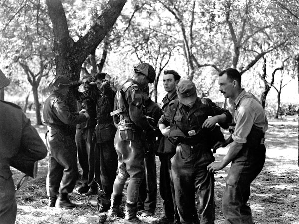 Infantrymen of The Royal Winnipeg Rifles searching German prisoners, Aubigny, France, ca.16-17 August 1944.