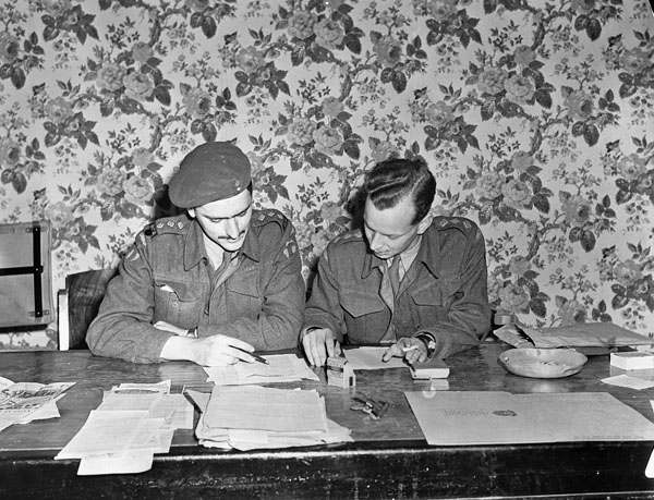 Captains Alan Duckett and Seth Halton censoring copy to be printed in the first issue of the Maple Leaf newspaper, Caen, France, 28 July 1944.