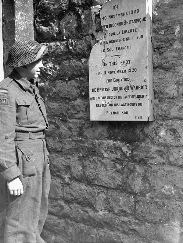 Signalman F.R.J. Savage of the Royal Canadian Corps of Signals (R.C.C.S.) and the 9th Canadian Infantry Brigade reads the inscription on a plaque dedicated to an unknown British soldier buried on 9-10 November 1920. Boulogne, France, 19 September 1944.