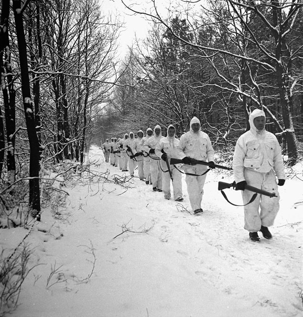 Infantrymen of the Queen's Own Rifles of Canada, who wear full British snow camouflage kit, go on patrol near Nijmegen, Netherlands, 22 January 1945.