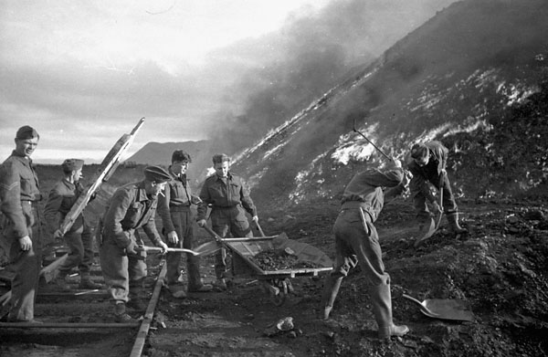 Sappers of the 3rd Field Company, Royal Canadian Engineers (R.C.E.), burning coal piles during Operation GAUNTLET, the Spitsbergen raid, Barentsburg, Spitsbergen, ca. 27 August - 2 September 1941.