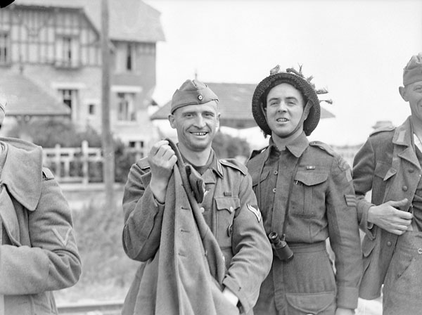 Sergeant R. Gagnon of Le Régiment de la Chaudière with a German prisoner on Nan White Beach, Bernières-sur-Mer, France, 6 June 1944.