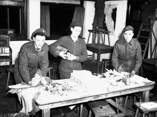 Personnel of No. 2 Motor Ambulance Convoy Detachment, Royal Canadian Army Service Corps (R.C.A.S.C.), packing bags of candy for distribution at a Christmas party for Dutch children, Nijmegen, Netherlands, 20 December 1944.