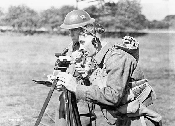Unidentified Gun Position Officer lining up the guns of the 1st Medium Regiment, Royal Canadian Artillery (R.C.A.), with the director during a training exercise, England, August 1941.