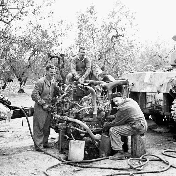 Personnel of the 1st Armoured Brigade Workshop, Royal Canadian Electrical and Mechanical Engineers (R.C.E.M.E.) working on the engine of a Sherman tank of the 5th Canadian Armoured Division, Italy, 13 October 1943.
