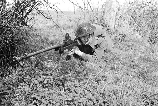An unidentified private of The Highland Light Infantry of Canada, who is armed with a Boys anti-tank rifle, taking part in a training exercise, Bognor Regis, England, 7 April 1942.