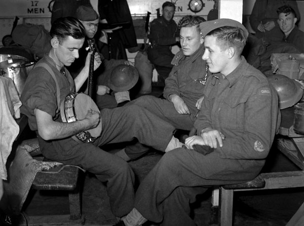 Unidentified Canadian soldiers relaxing aboard the troopship S.S. PASTEUR, which is part of Convoy T.C.14 en route from Halifax, Nova Scotia, Canada, to Glasgow, Scotland, 14 November 1941.